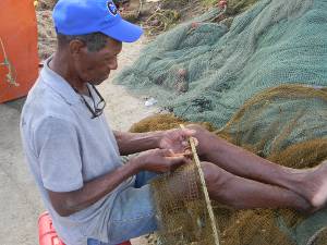 Pescador arreglando su red